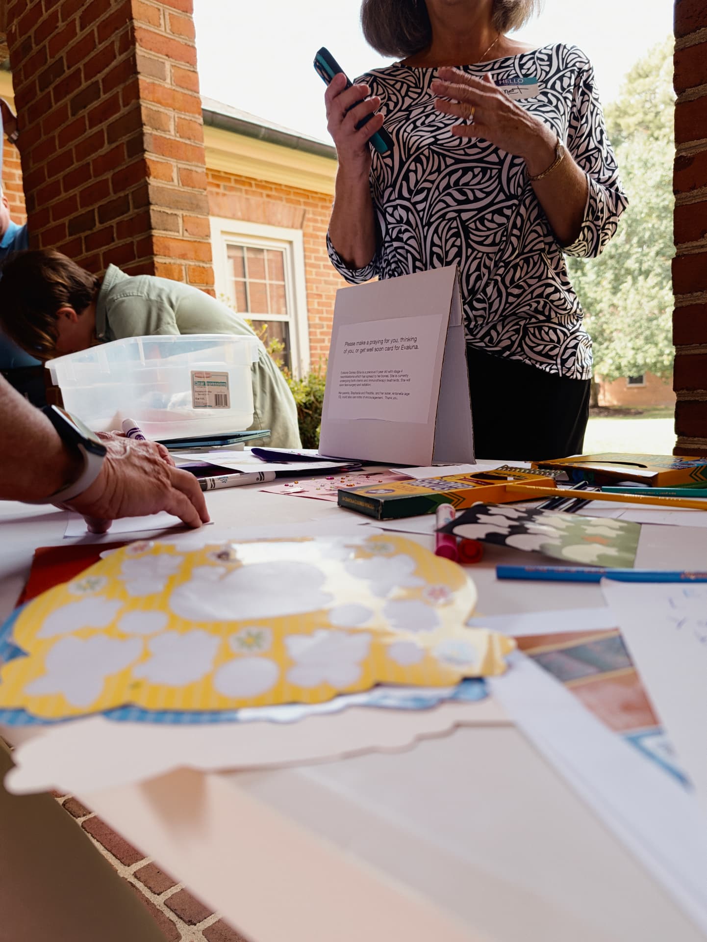 Volunteers making cards and crafts at an outdoor table
